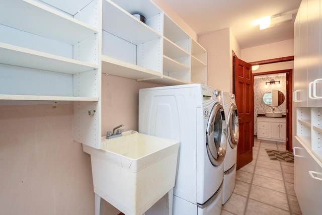 laundry room featuring sink, washer and dryer, and light tile patterned flooring