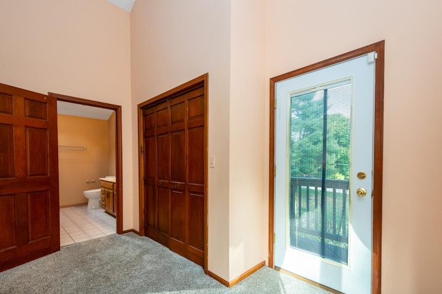 interior space featuring a high ceiling and light colored carpet