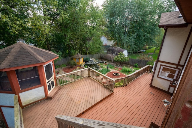 wooden terrace with a gazebo and a shed