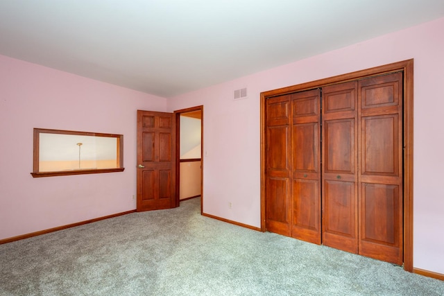 unfurnished bedroom with light carpet and a closet