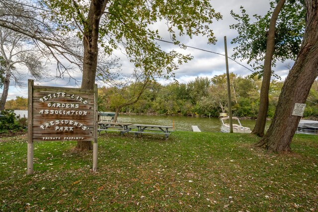 view of community with a water view and a lawn