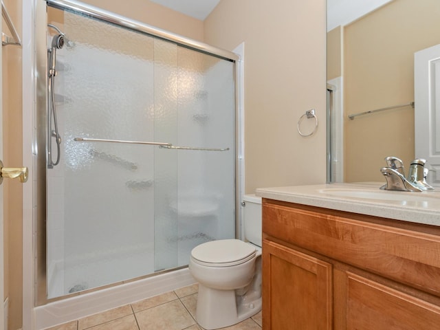 bathroom with tile patterned flooring, vanity, toilet, and walk in shower