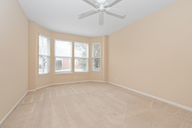 empty room with ceiling fan and light carpet