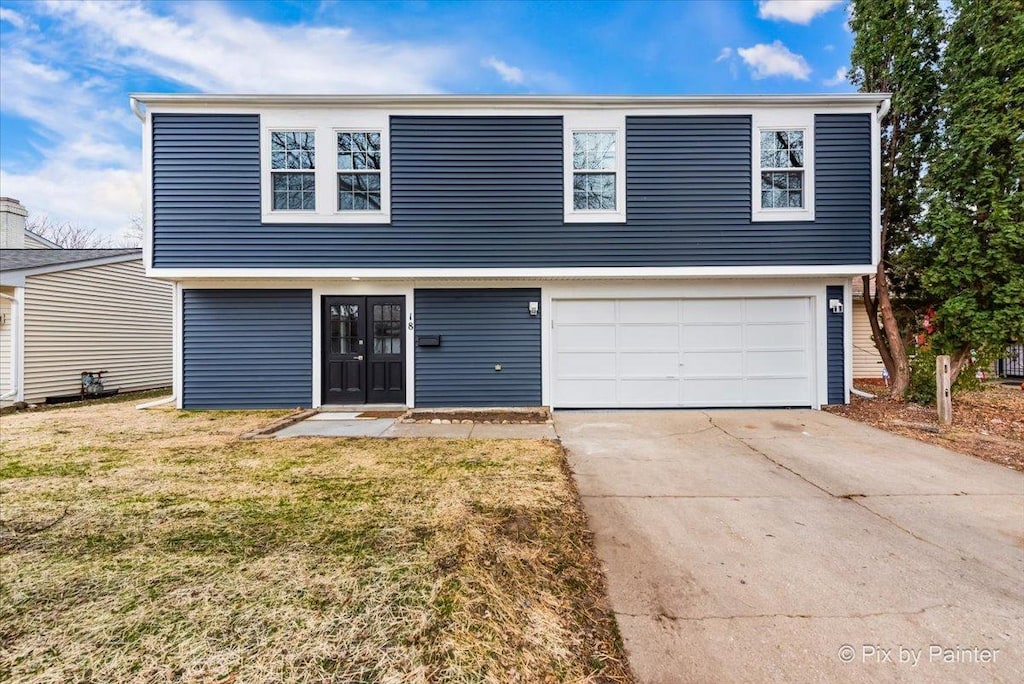 front facade with a front yard and a garage