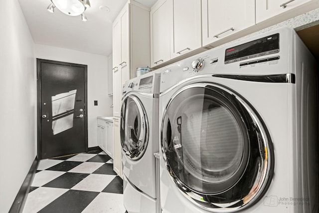 laundry area featuring separate washer and dryer and cabinets