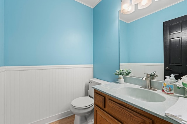 bathroom featuring ornamental molding, toilet, hardwood / wood-style floors, and vanity