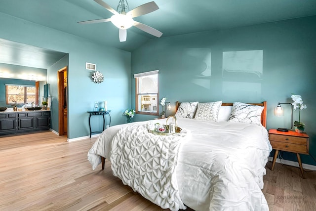 bedroom with vaulted ceiling, a closet, a spacious closet, ceiling fan, and light hardwood / wood-style flooring