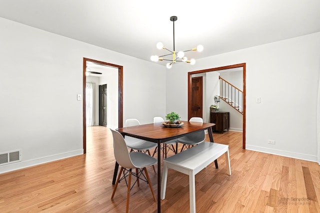 dining space with a chandelier and light hardwood / wood-style flooring