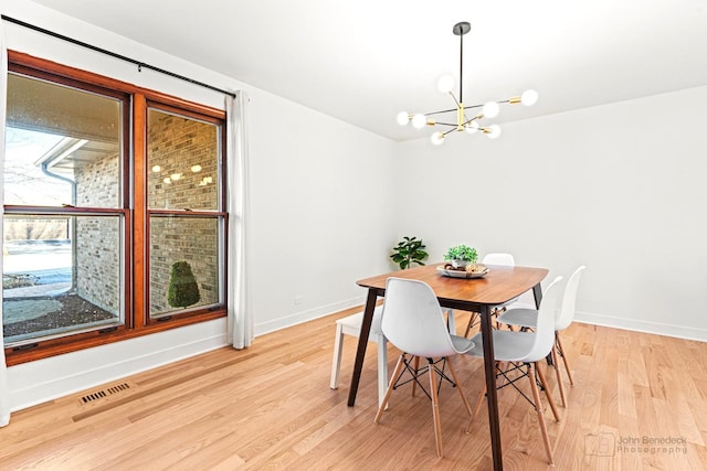 dining room featuring an inviting chandelier and light hardwood / wood-style flooring