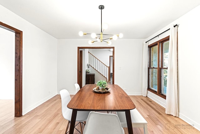 dining room with light hardwood / wood-style floors and a notable chandelier