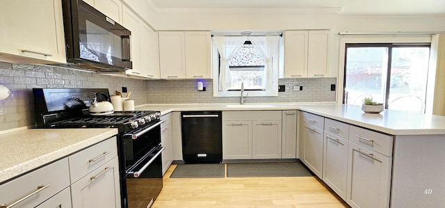 kitchen featuring tasteful backsplash, a wealth of natural light, sink, and black appliances