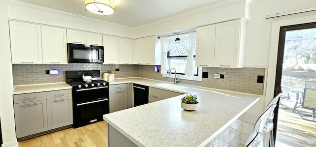 kitchen with gray cabinets, tasteful backsplash, sink, and black appliances