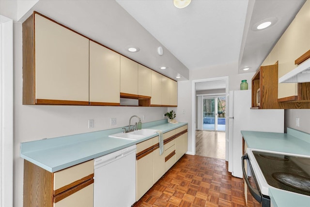 kitchen featuring sink, white appliances, and dark parquet flooring