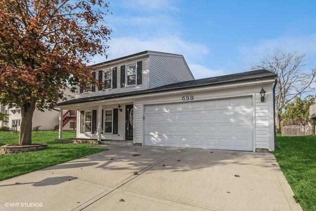 traditional-style house featuring a garage, concrete driveway, and a front lawn