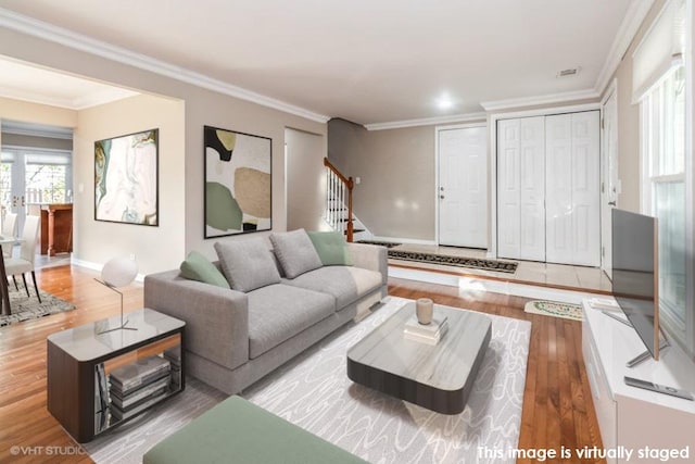 living area featuring ornamental molding, stairway, wood finished floors, and baseboards