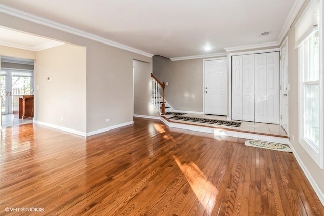 interior space with crown molding, wood-type flooring, plenty of natural light, baseboards, and stairs