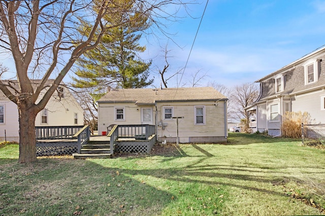 rear view of property with a yard and a deck