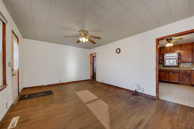 unfurnished room featuring ceiling fan, sink, wood-type flooring, and a textured ceiling