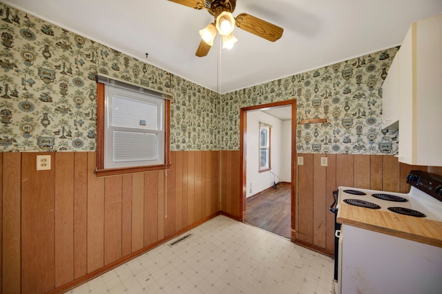 empty room with ceiling fan and wooden walls