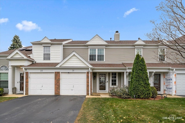 multi unit property featuring a garage and a front lawn