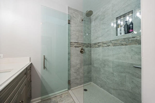 full bath featuring a tile shower and vanity