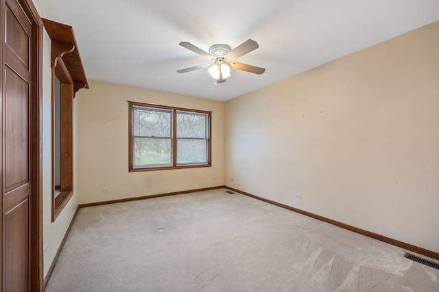 unfurnished bedroom with a ceiling fan, light carpet, visible vents, and baseboards