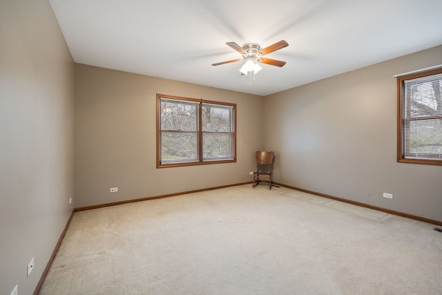 empty room featuring light carpet, ceiling fan, and baseboards