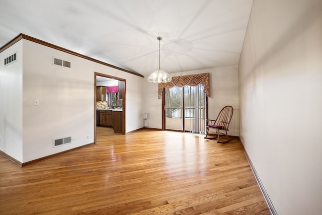 interior space with visible vents, a notable chandelier, and light wood-style flooring