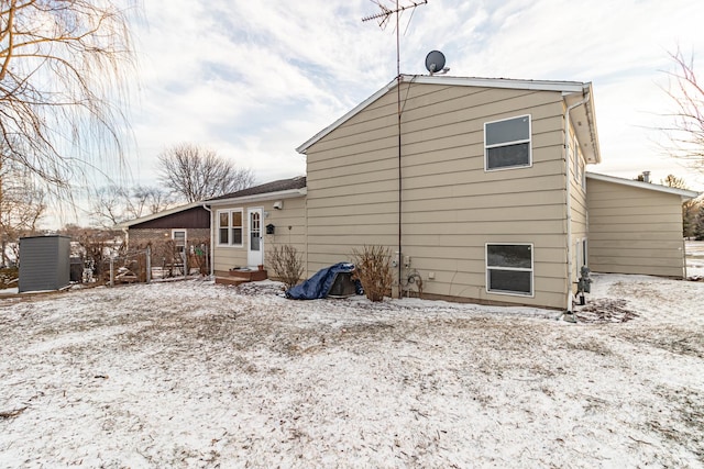 view of snow covered rear of property