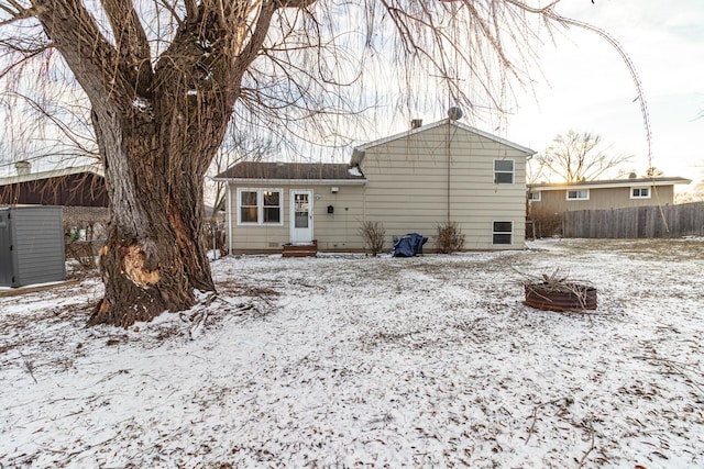 view of snow covered back of property