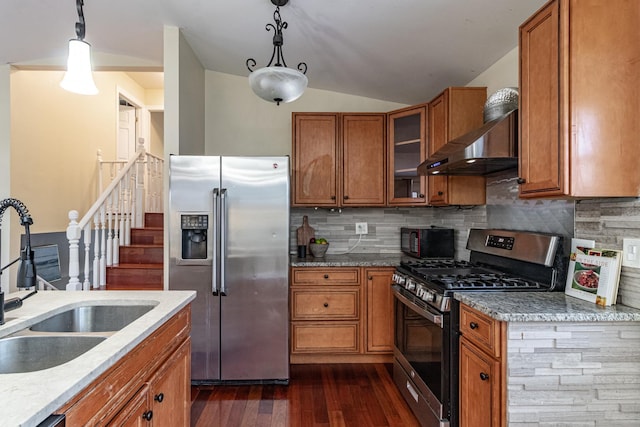 kitchen with appliances with stainless steel finishes, decorative light fixtures, tasteful backsplash, and sink