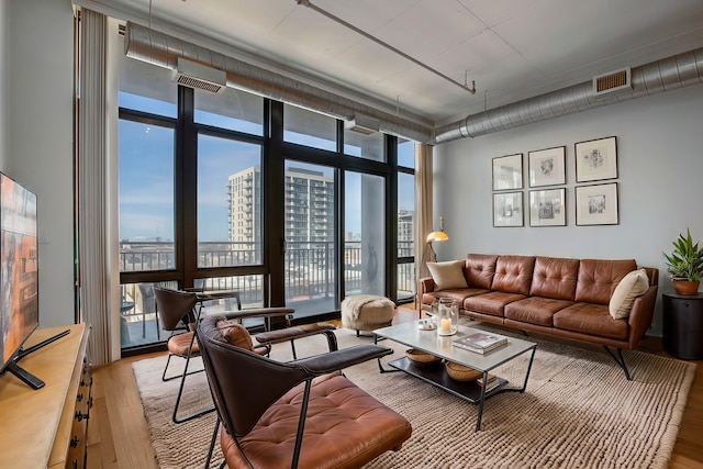 living room with plenty of natural light, expansive windows, and light hardwood / wood-style floors