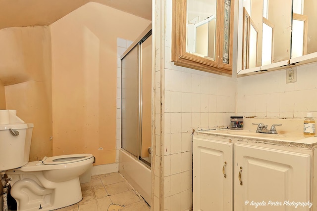 full bathroom featuring tile patterned floors, vanity, toilet, and enclosed tub / shower combo