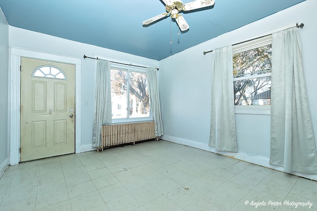 entryway with ceiling fan, radiator heating unit, and a wealth of natural light