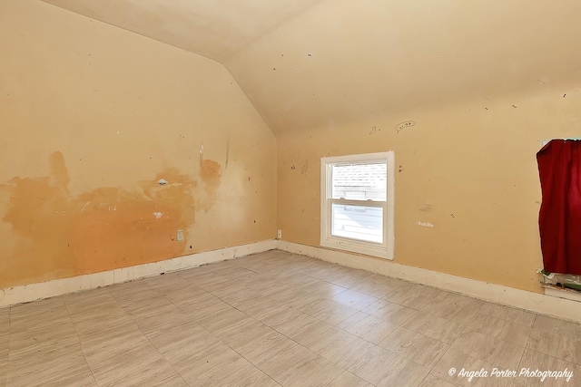 spare room featuring lofted ceiling