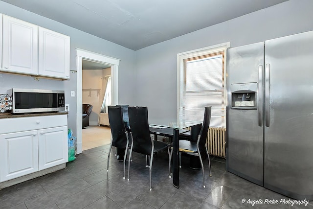 dining space featuring dark tile patterned floors