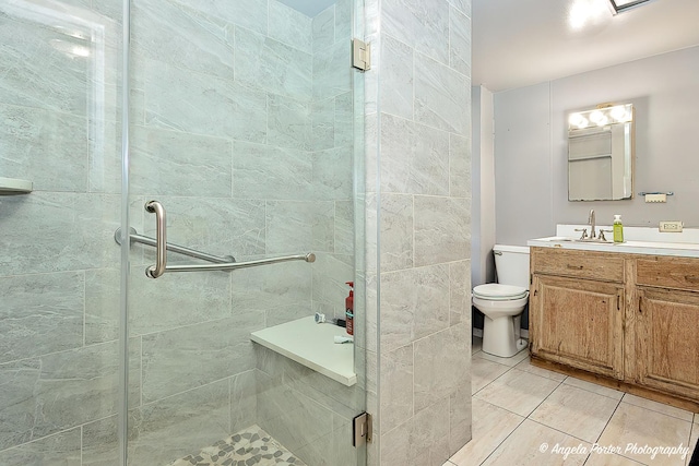 bathroom with tile patterned flooring, vanity, an enclosed shower, and toilet