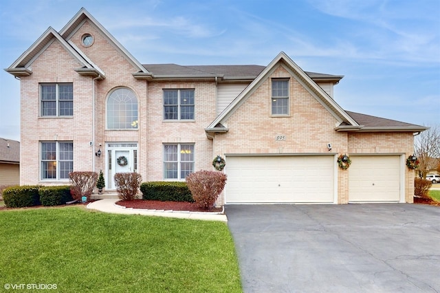 view of front of house with a front yard and a garage