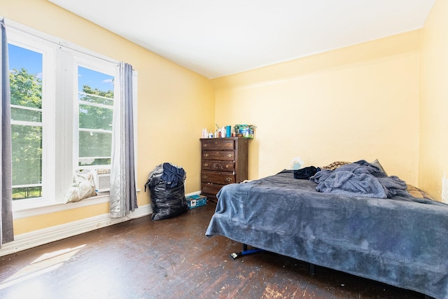 bedroom with multiple windows and dark wood-type flooring