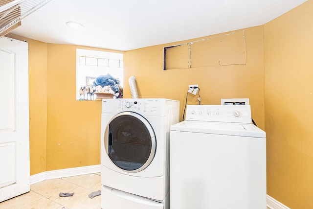 laundry area with light tile patterned floors and washer and clothes dryer