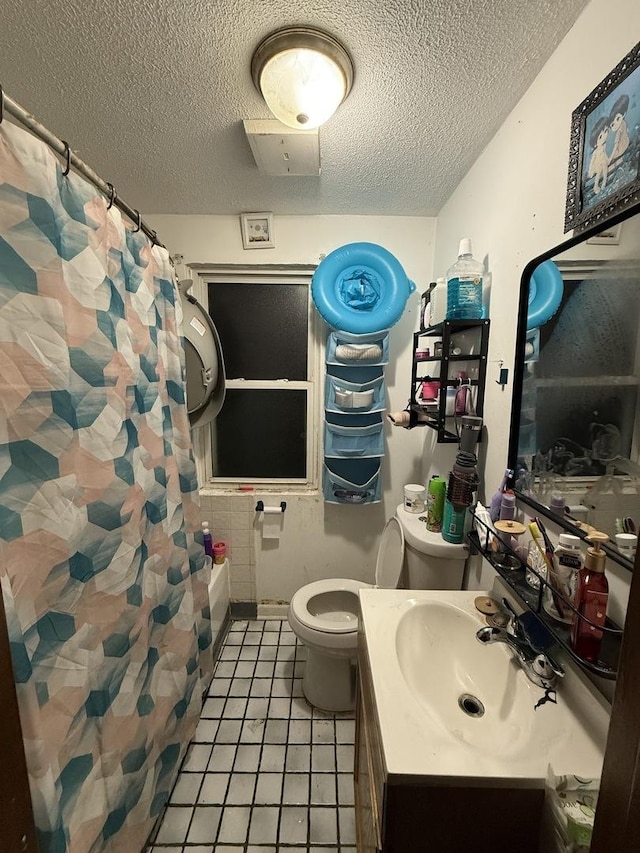 full bathroom featuring vanity, tile patterned floors, toilet, a textured ceiling, and shower / tub combo