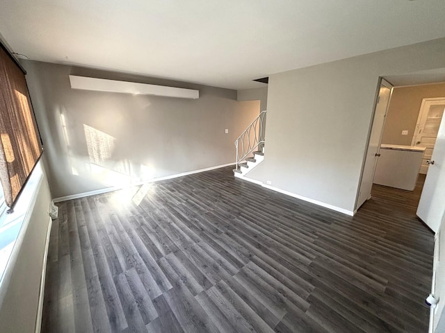 unfurnished living room with dark wood-type flooring