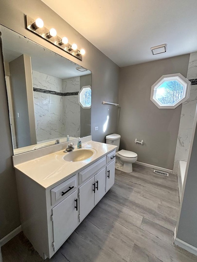 bathroom with vanity, toilet, and wood-type flooring