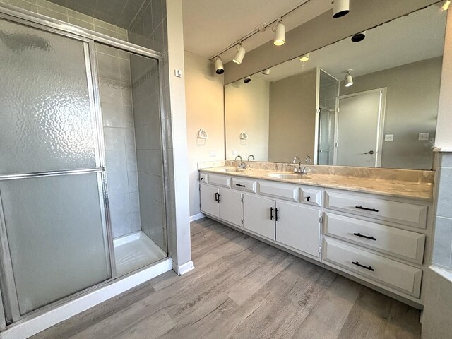 bathroom with vanity, an enclosed shower, and hardwood / wood-style flooring