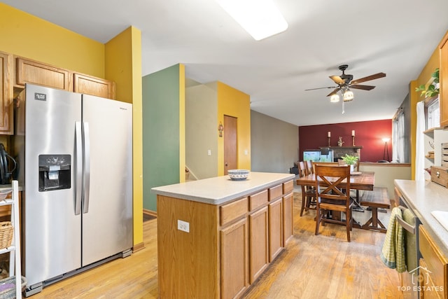 kitchen featuring ceiling fan, a center island, light wood-type flooring, and stainless steel fridge with ice dispenser