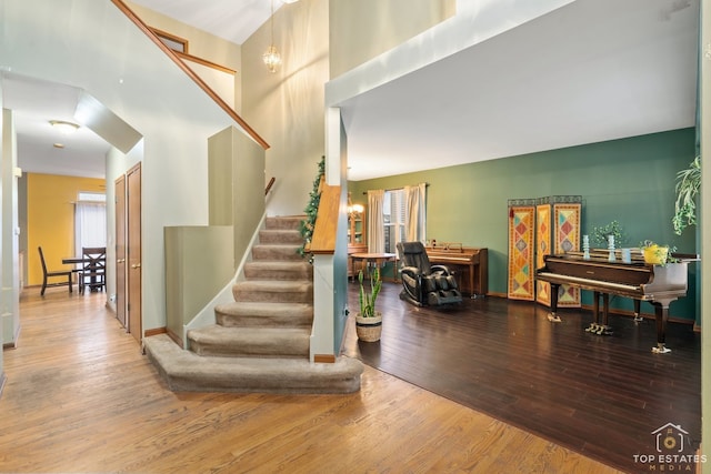 staircase featuring hardwood / wood-style floors and a towering ceiling