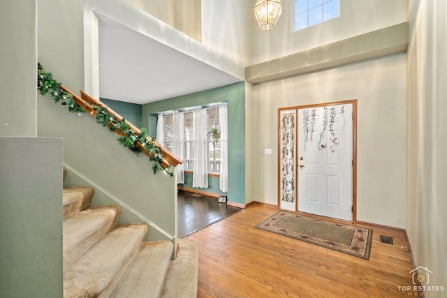 foyer entrance with hardwood / wood-style floors and an inviting chandelier