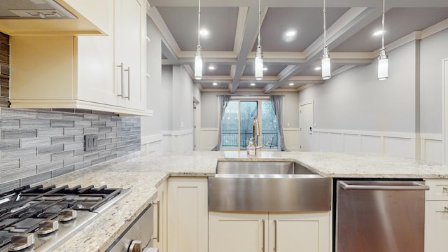 kitchen with pendant lighting, light stone countertops, sink, and stainless steel appliances