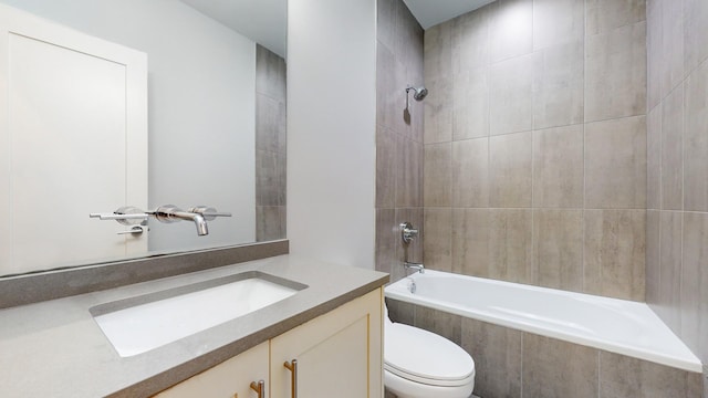 full bathroom featuring vanity, tiled shower / bath combo, and toilet