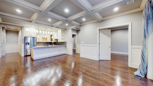 interior space featuring white cabinetry, tasteful backsplash, dark hardwood / wood-style floors, kitchen peninsula, and stainless steel fridge